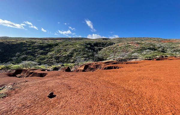 on this once beautiful island, red hard-pan shows the devastation